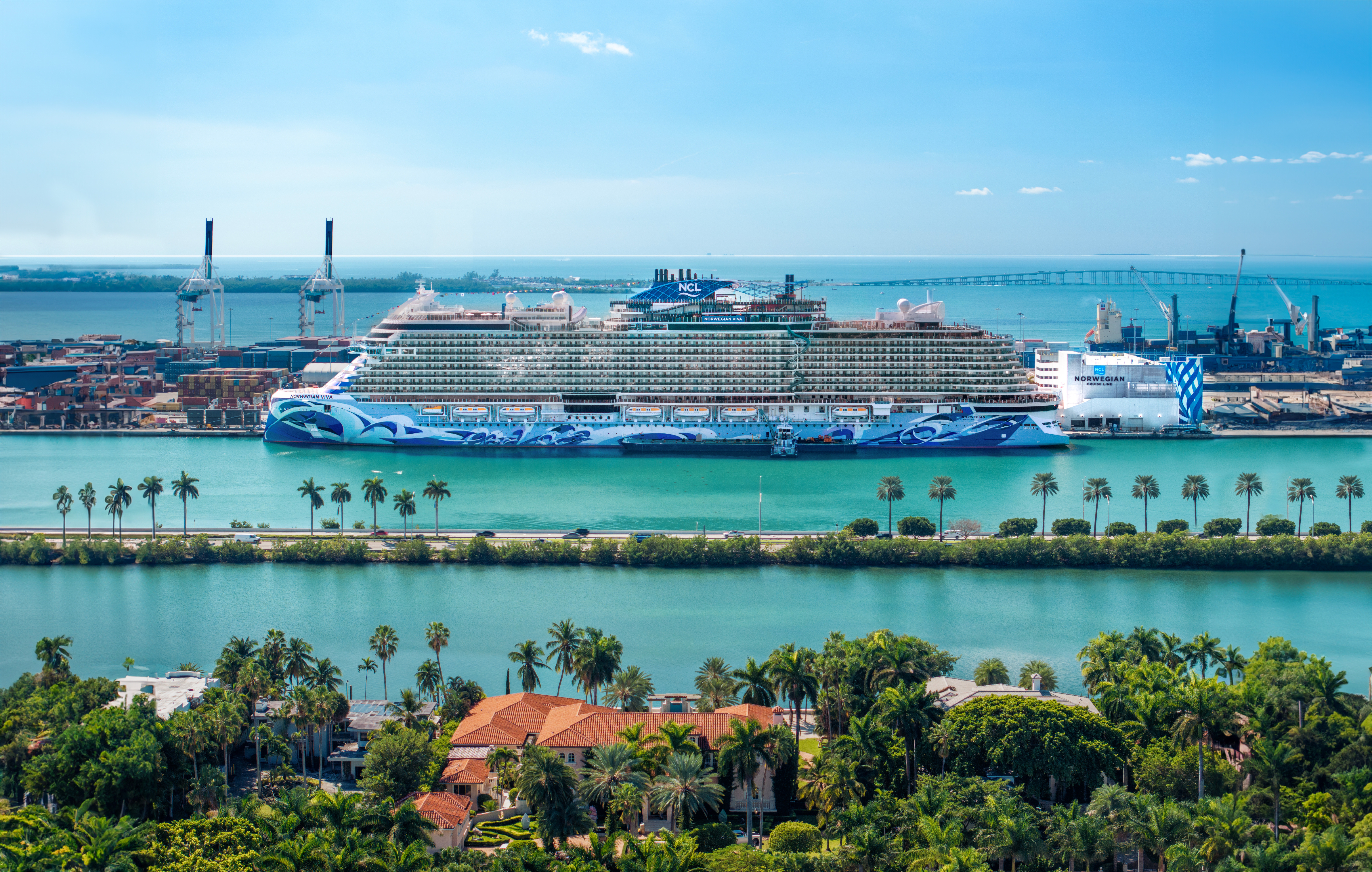 Norwegian cruise ship at port with palm trees and clear blue water